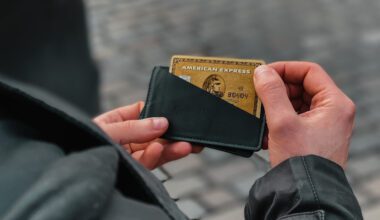 Mann hält Portemonnaie mit einer American Express Gold Card in den Händen