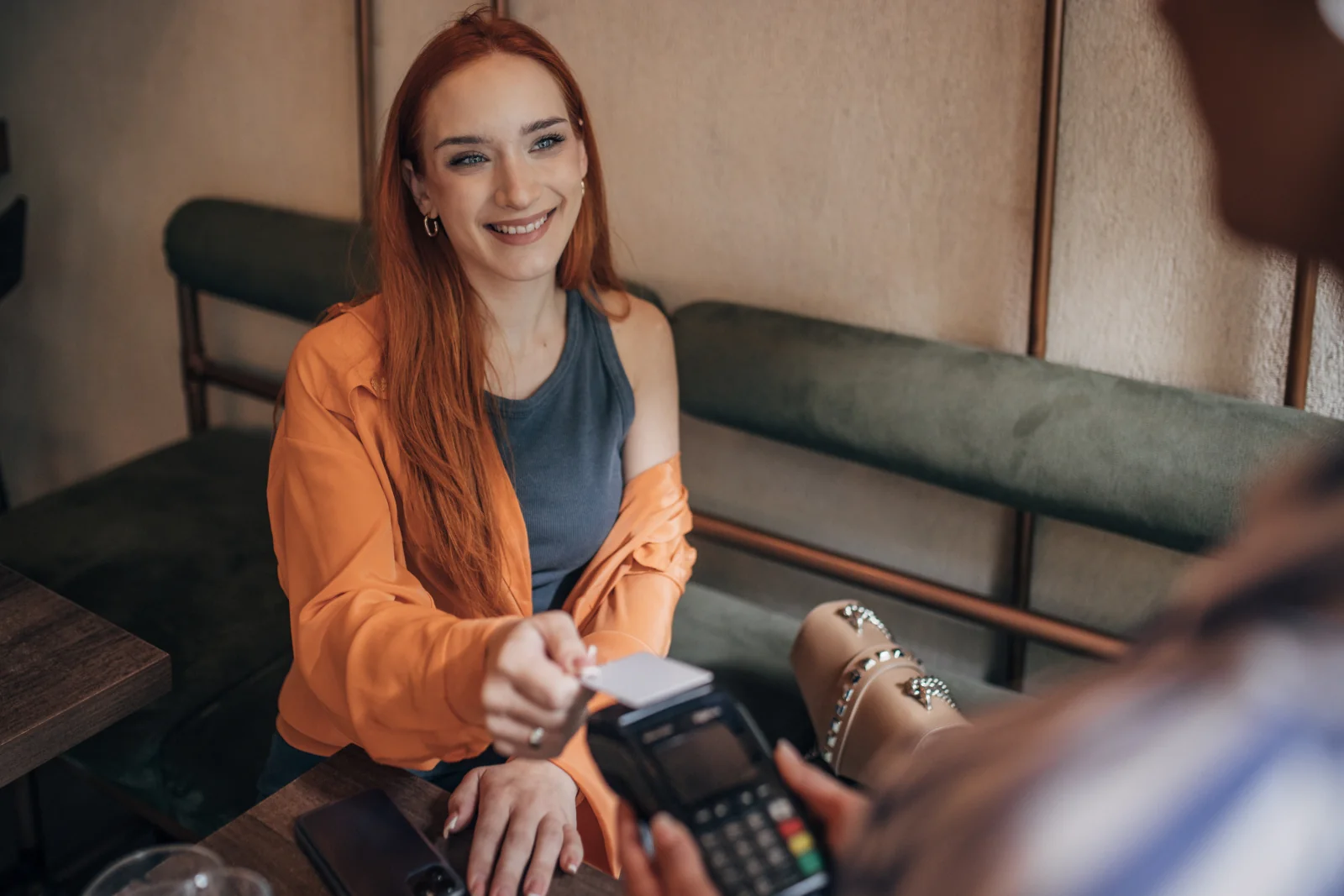 Frau bezahlt im Restaurant mit Kreditkarte