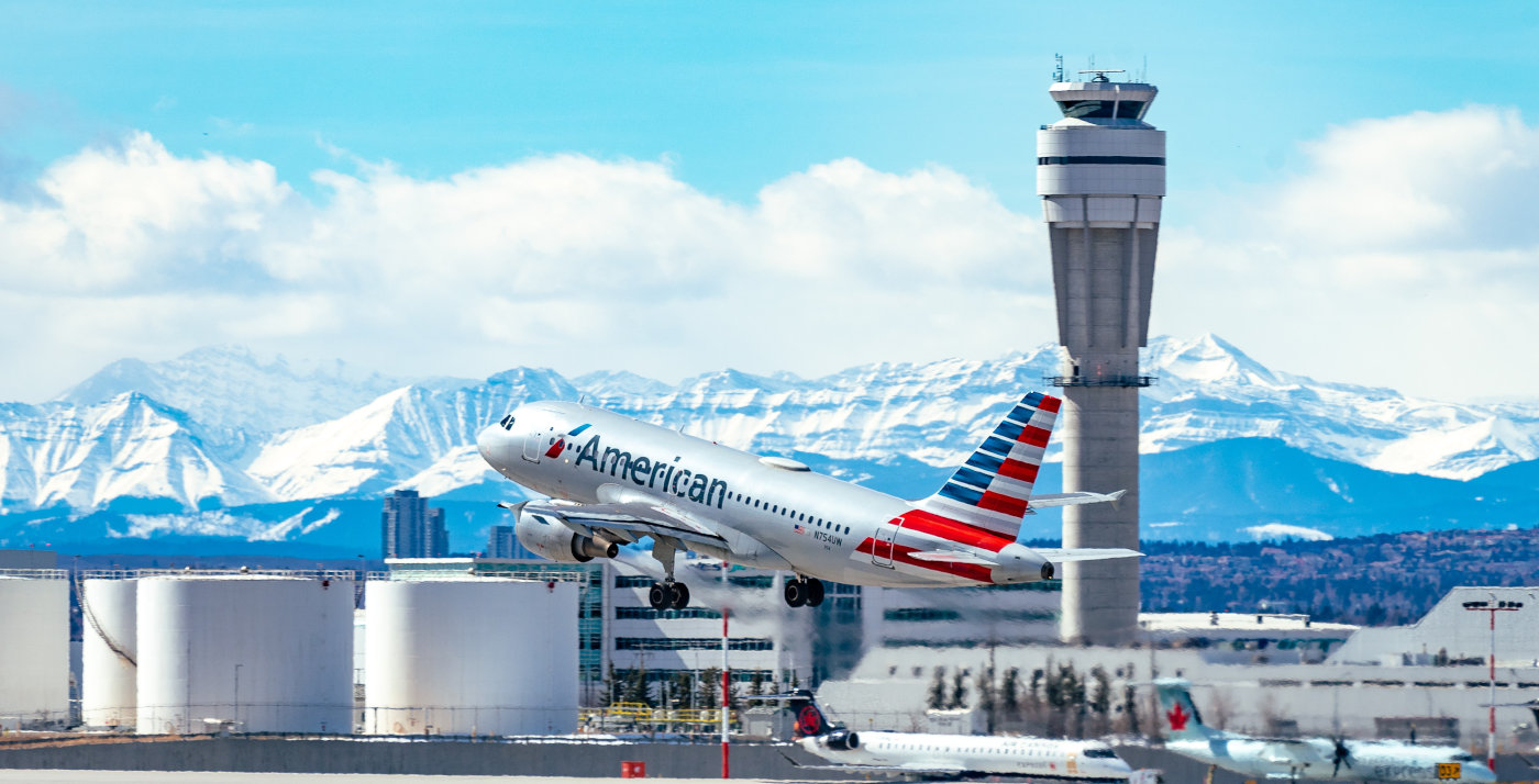 ein Flugzeug von American Airlines startet mit Tower im Hintergrund