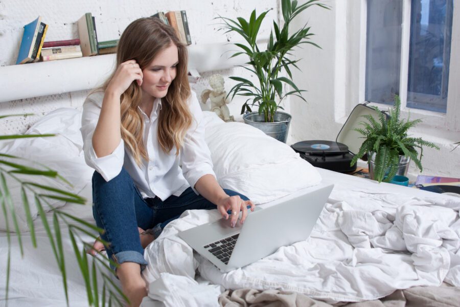 Junge Frau am Laptop beantragt einen Wyndham Rewards Status Match