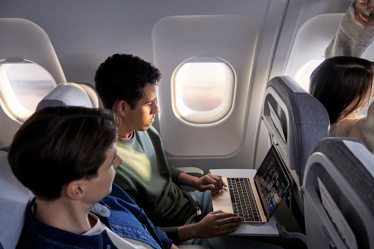 Mann am Fenster eines Finnair Airbus A321 arbeitet an seinem Laptop