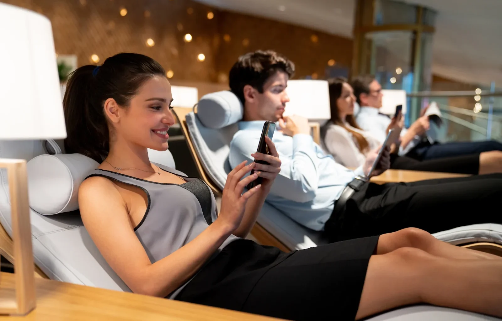 junge selbstständige Geschäftsfrau wartet entspannt in einer Flughafen-Lounge auf ihren Flug