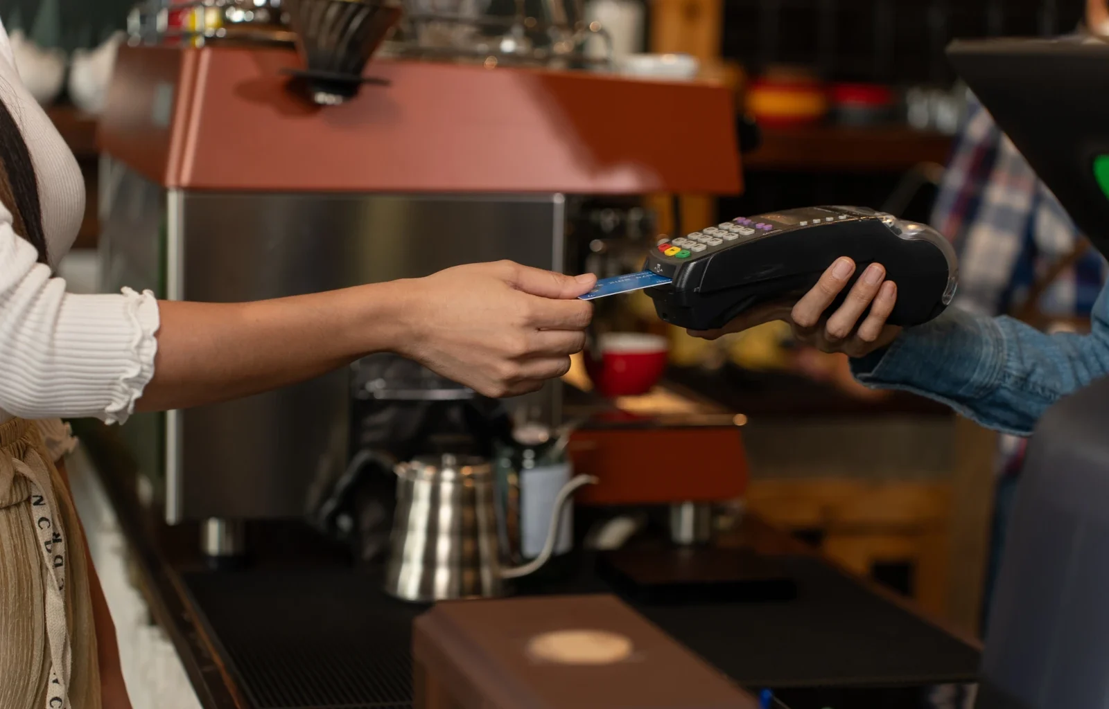 Kontaktloses Bezahlen mit Kreditkarte, Kundenfrau bezahlt Kaffee mit Kreditkarte im Café. Kleinunternehmen, Geschäftsinhaber.