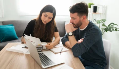 junges Paar Überweisungen am Laptop Miles & More beendet Meilengutschriften für Fintechs wie Revolut, Paypal, payzy, BVVA