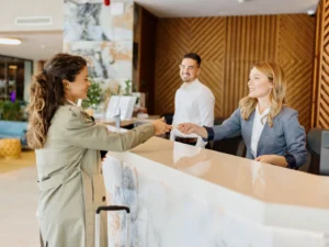 junge Frau bezahlt beim Check-in im Hotel mit Kreditkarte