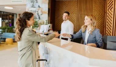 junge Frau bezahlt beim Check-in im Hotel mit Kreditkarte