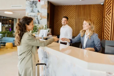 junge Frau bezahlt beim Check-in im Hotel mit Kreditkarte