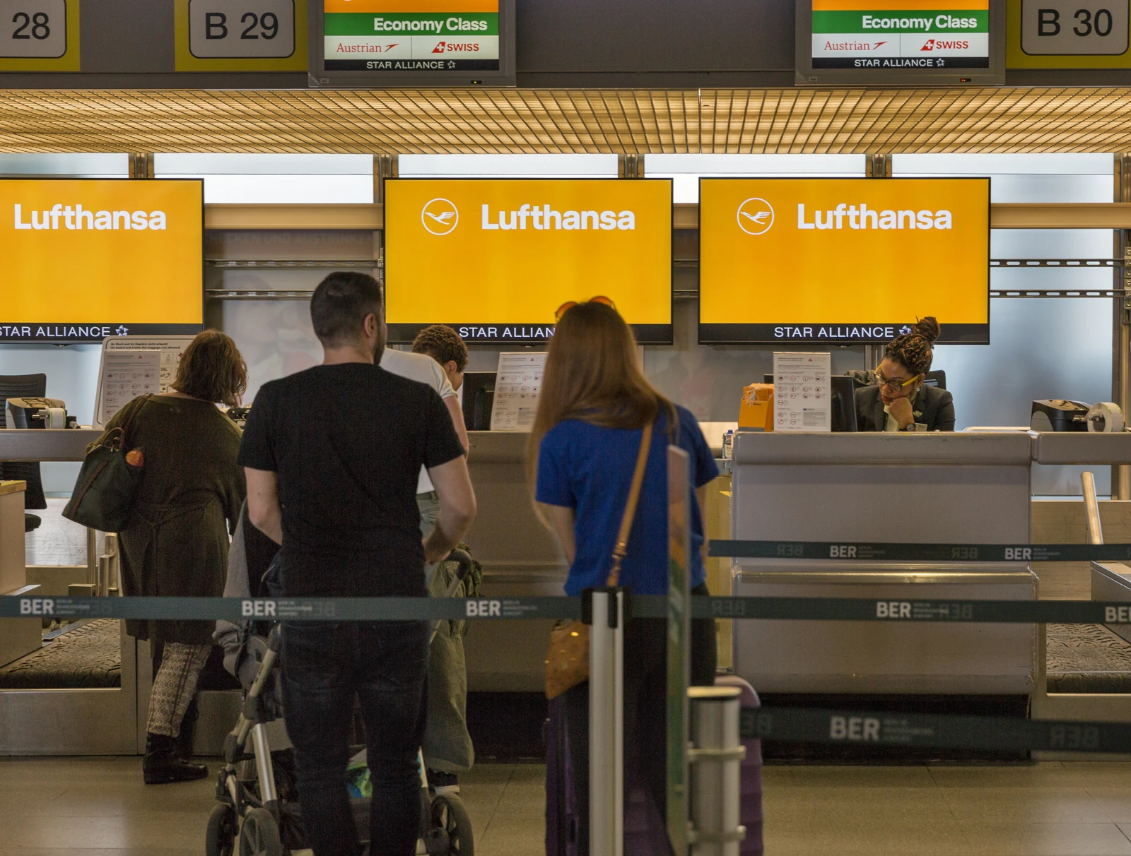 Familie mit Kindern am Lufthansa Check-in in Berlin können mit dem Miles & More Mileage Pooling gemeinsam Meilen sammeln