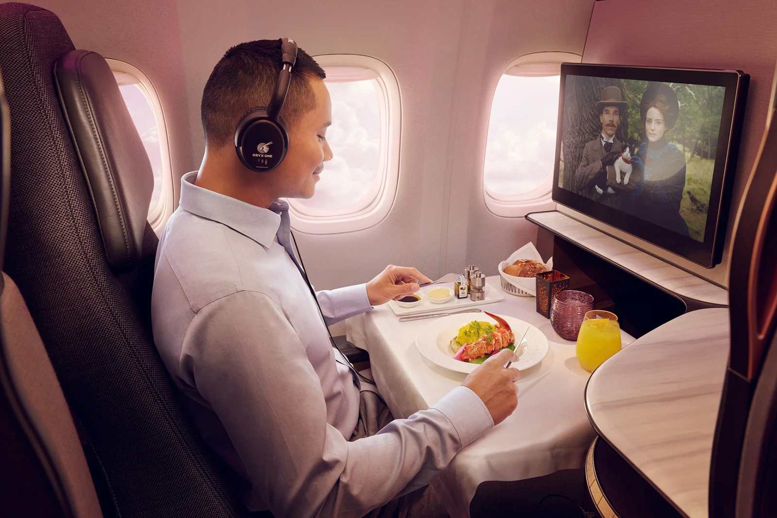 Mann genießt Catering in Qatar Airways Qsuite Business Class 