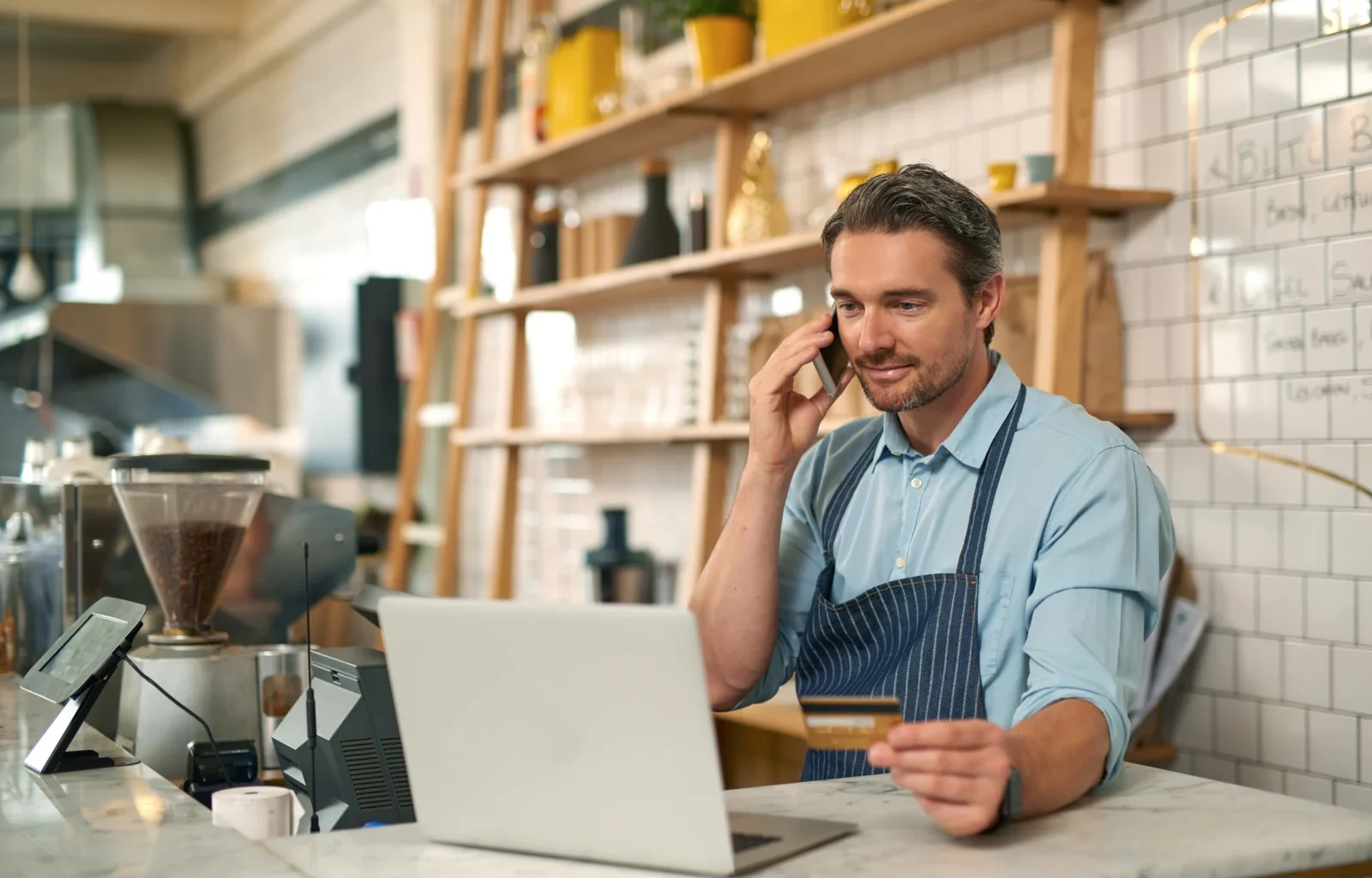 männlicher Barista macht eine Online-Bestellung mit einer Business Zusatzkarte