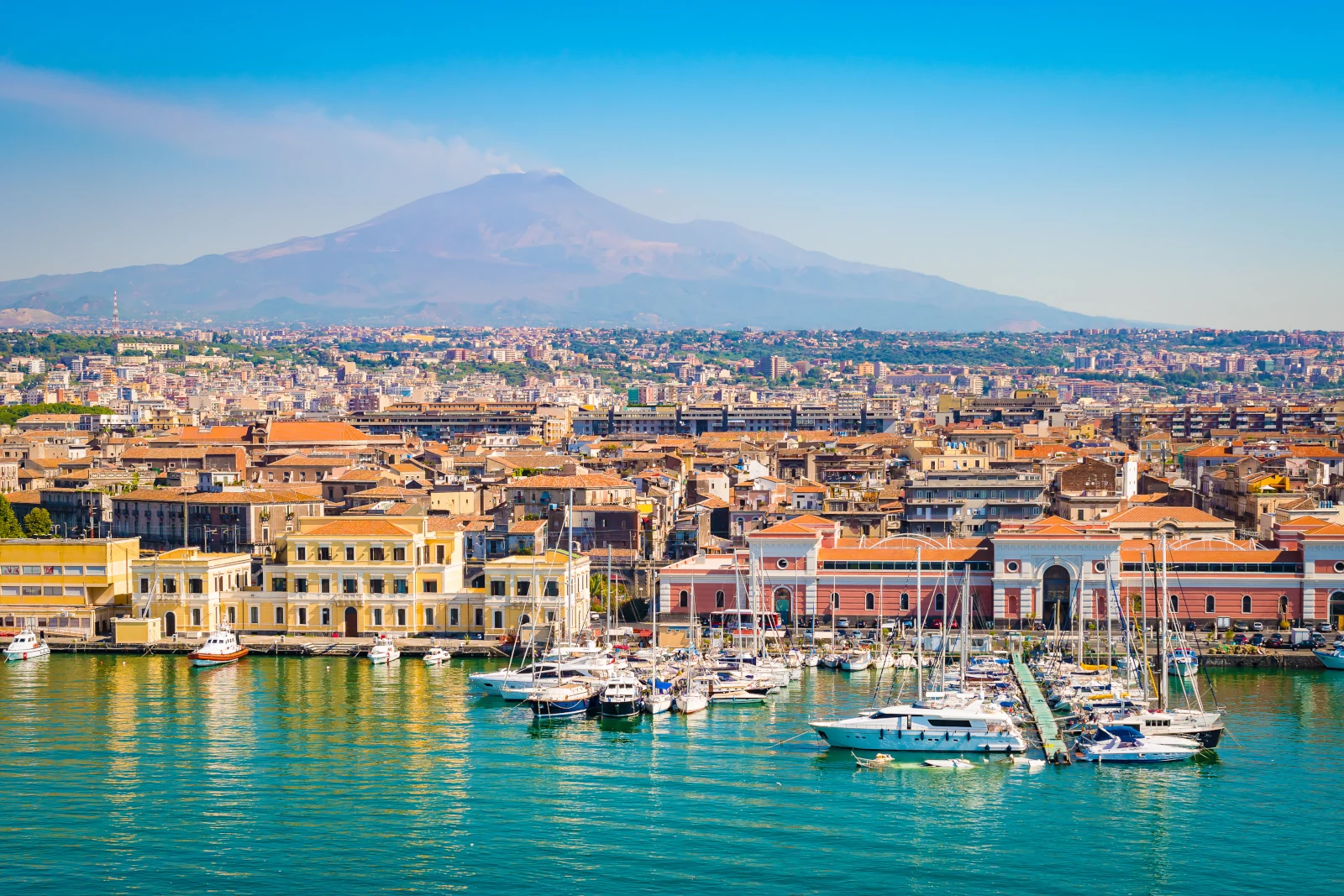 Schöne Aussicht auf den Kreuzfahrthafen von Catania mit rauchendem Vulkan Ätna im Hintergrund