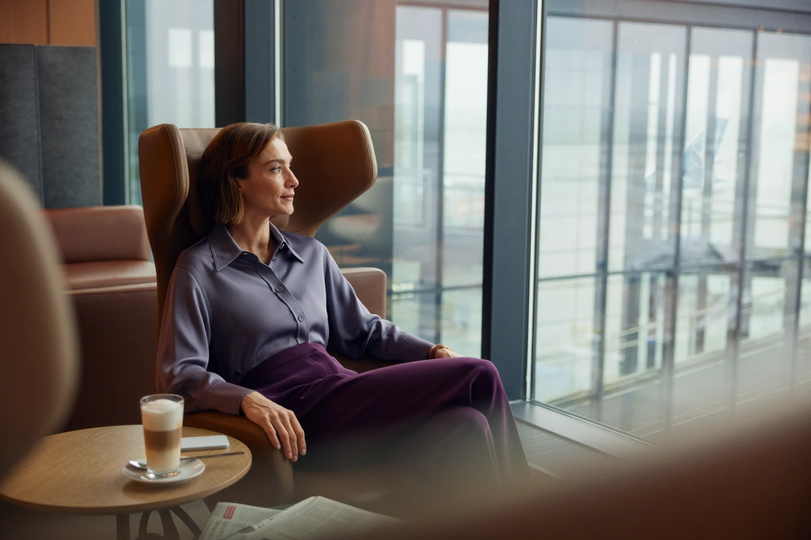 Frau sitzt in der Senator Lounge Berlin und wartet auf ihren Eurowings Flug im Basic-Tarif