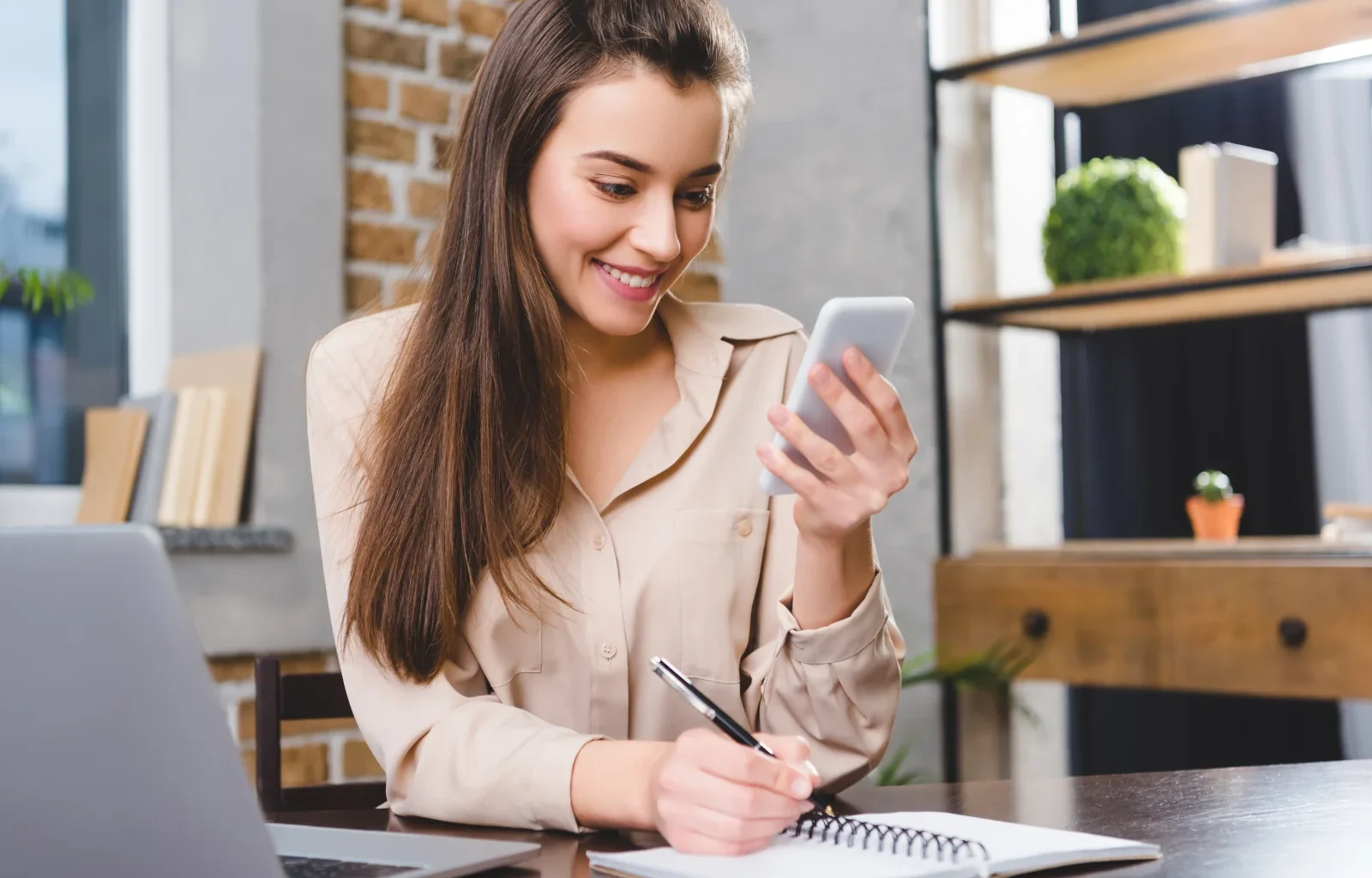 junge Frau am Laptop und Smartphone registriert sich für die neuste IHG On Rewards Bonuspunkte-Promotion