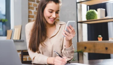 junge Frau am Laptop und Smartphone registriert sich für die neuste IHG On Rewards Bonuspunkte-Promotion