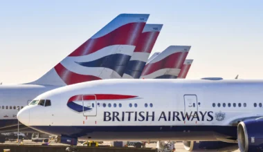 Das von British Airways betriebene Langstreckenflugzeug Boeing 777 rollt für den Start an den Heckflossen der anderen Flugzeuge des Unternehmens vorbei.