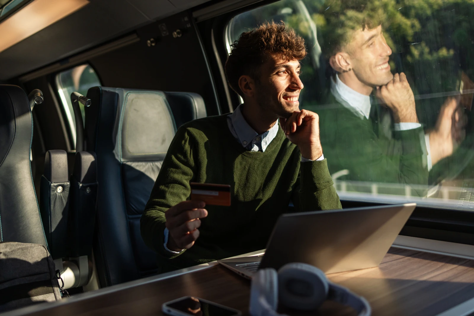 junger Mann mit nutzt als Anfänger gern die Amex Gold zum Sammeln von Punkten im Zug