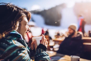 junge Frau auf der Hütte im Winterurlaub mit Accessoires ihres Amex Platinum Shoppingguthaben