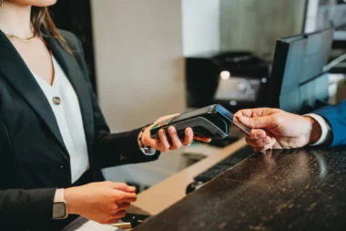 Mann bezahlt mit Amex Platinum oder Business Platinum an einer Hotelrezeption