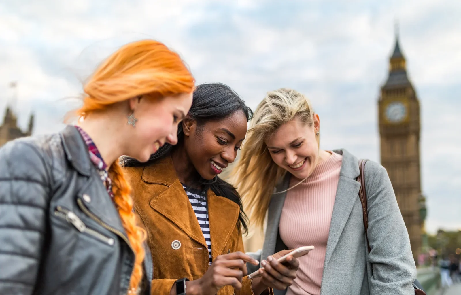 Gruppe von Mädchen in London neben Big Ben Städtereise überprüfen Karte auf dem Smartphone