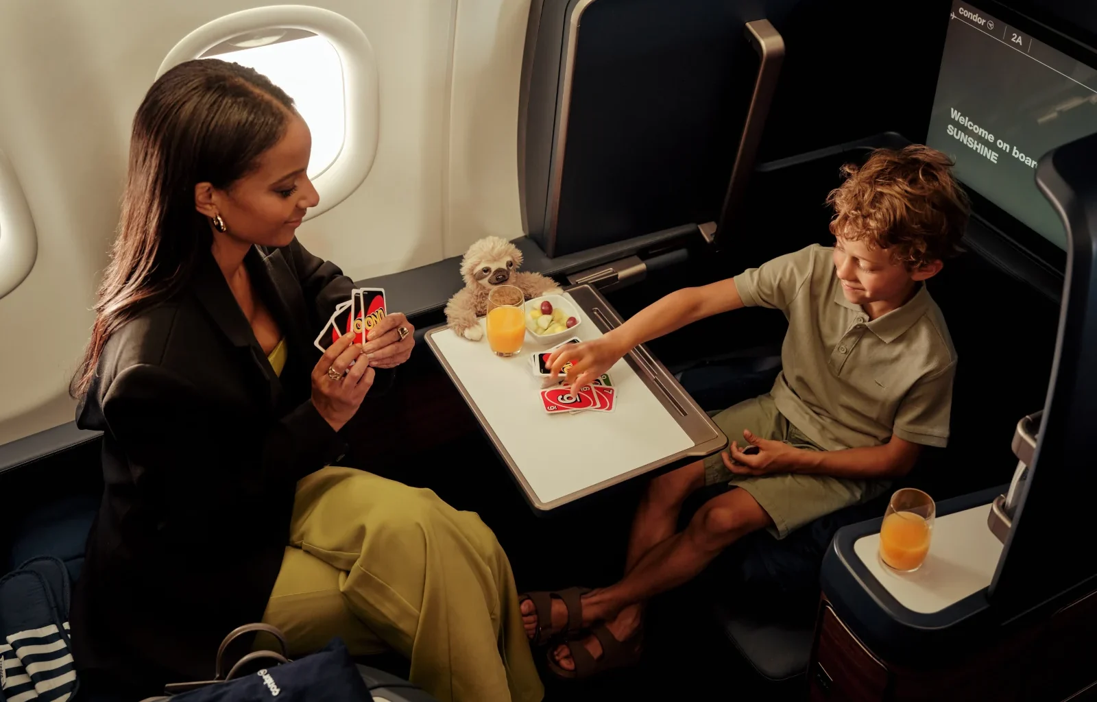 Condor Business Class Prime Seat Mutter spielt mit Kind UNO
