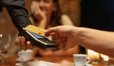 Mann bezahlt am Terminal mit einer Lufthansa Miles & More Kreditkarte der Deutschen Bank