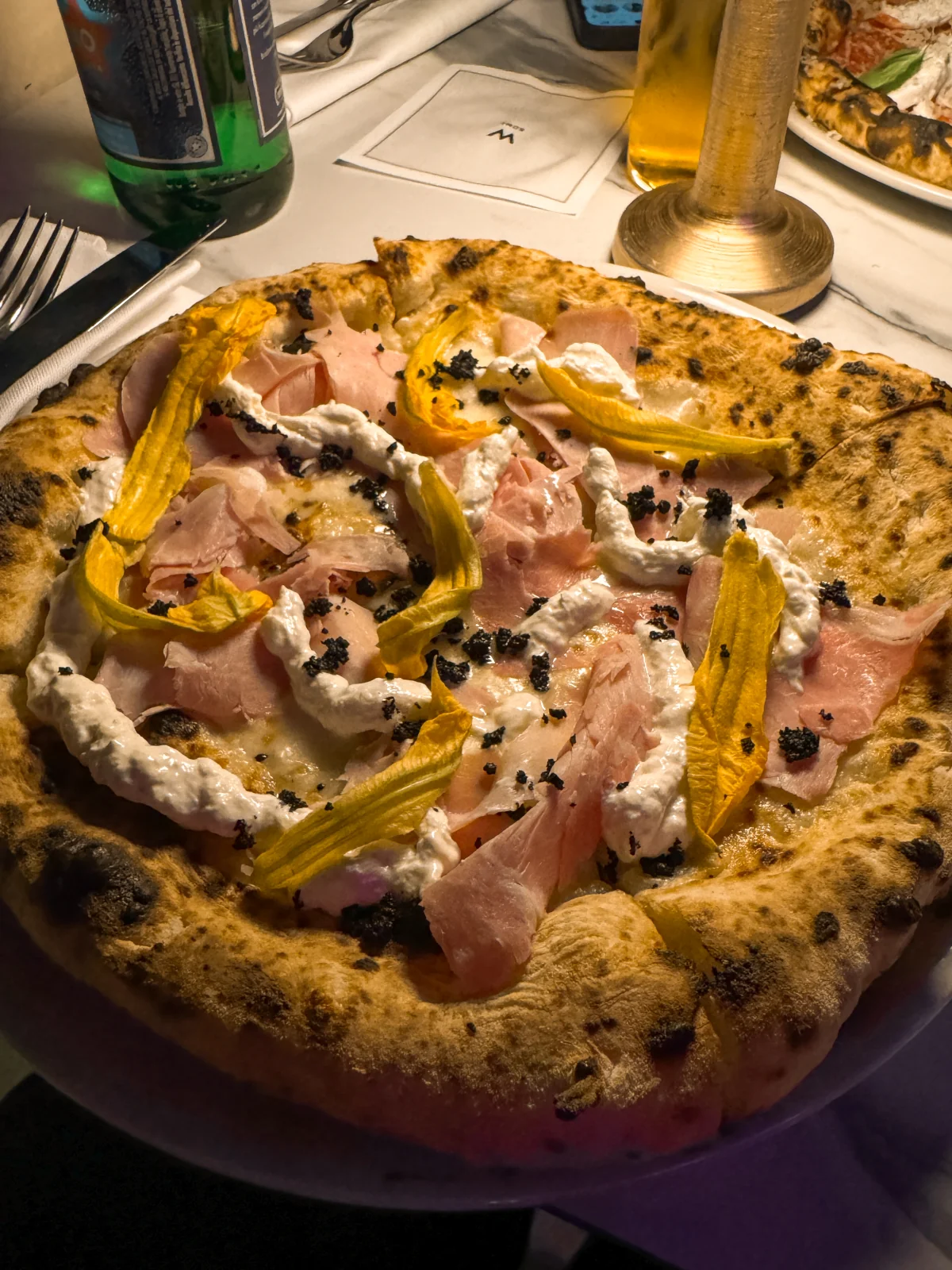 Seu Pizza con Vista Fior di cotto € 24 Fior di latte mozzarella, ham, zucchini flowers, burrata from Puglia, olives powder